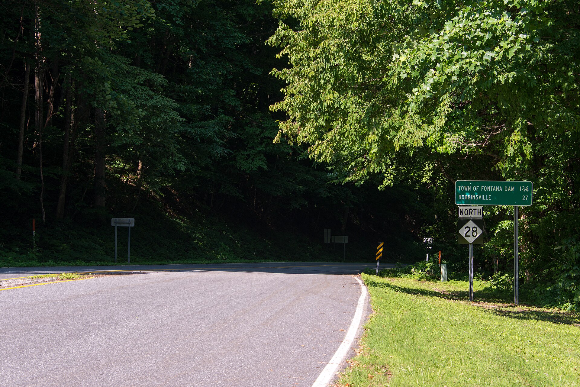 A North 28 route marker and distance sign in the woods